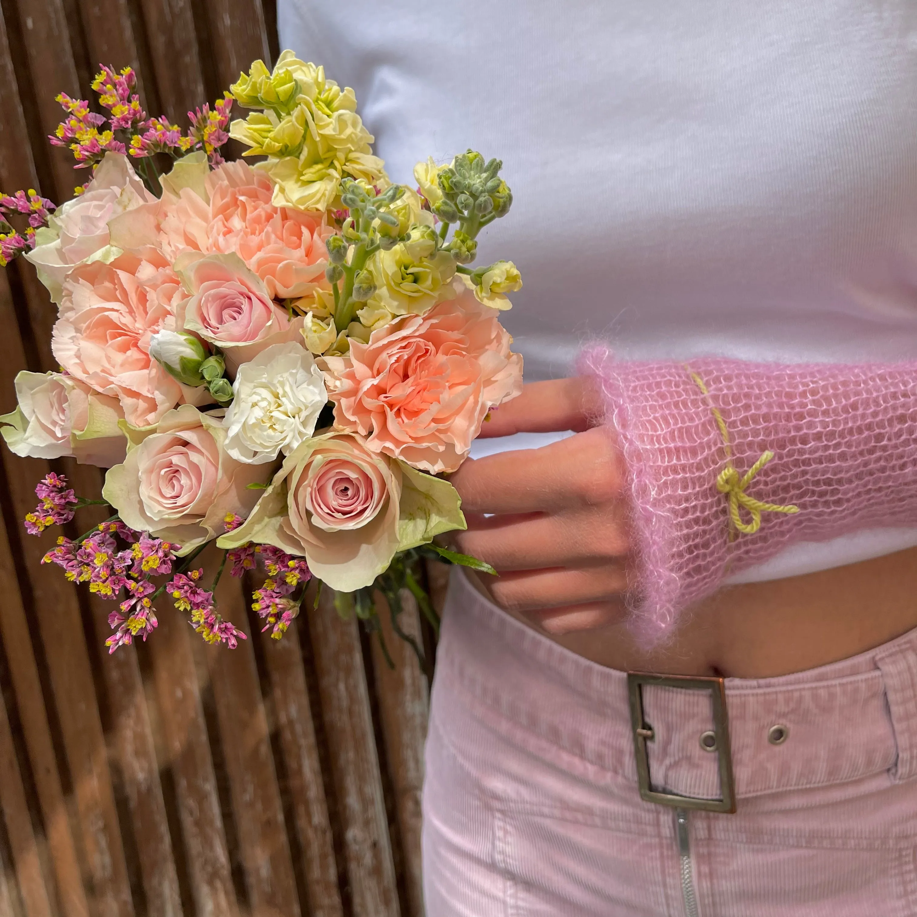 Handmade knitted mohair hand warmers in baby pink with lime green bow