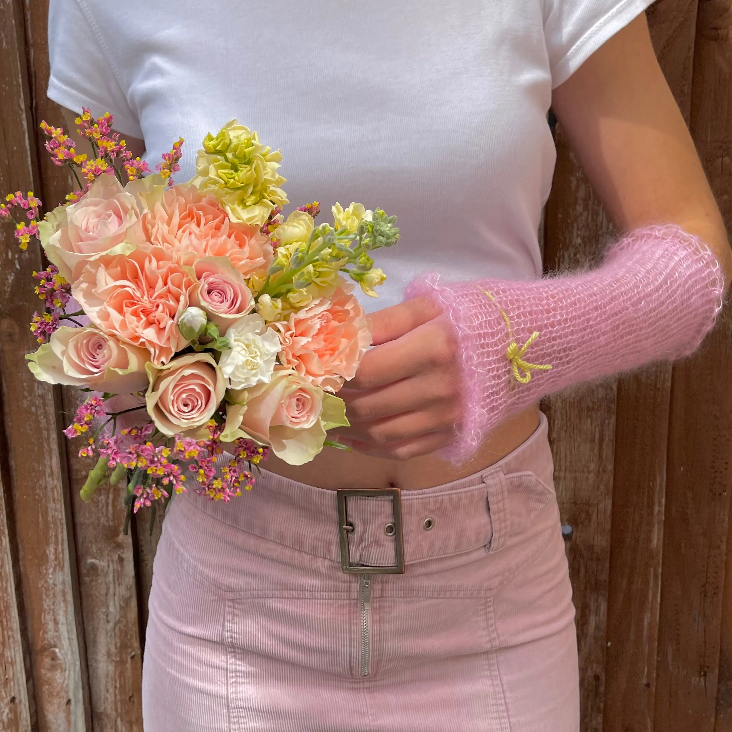 Handmade knitted mohair hand warmers in baby pink with lime green bow